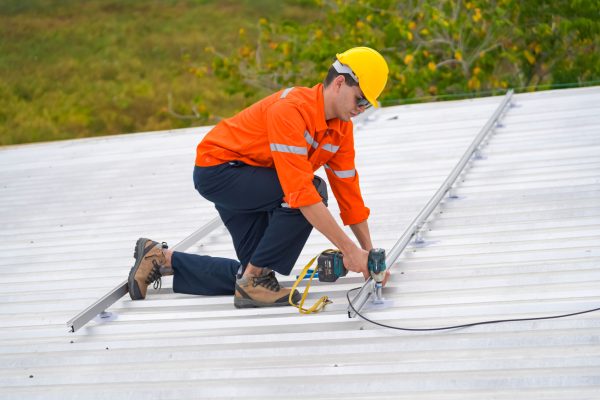 Men technicians mounting photovoltaic solar moduls on roof of house.